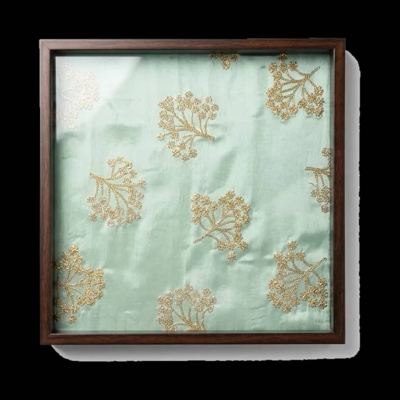 A serving tray floored in flowering celadon silk.