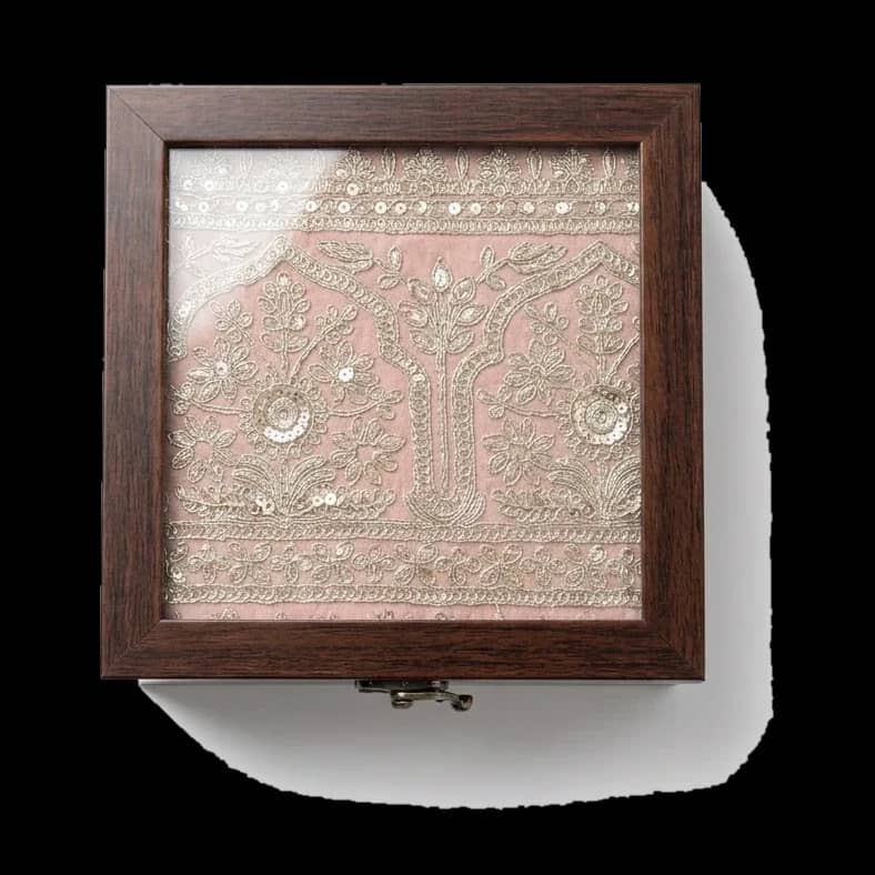 Blush silk under a dense lattice of gold embroidery.